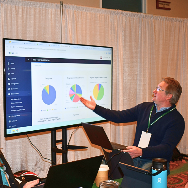 Joe LaForest, Southern IPM Center Co-Director, presents Connect Analytics at the 2025 IPM Symposium. He gestures towards a computer screen that displays graphs and charts about the Gulf South Vector Working Group.